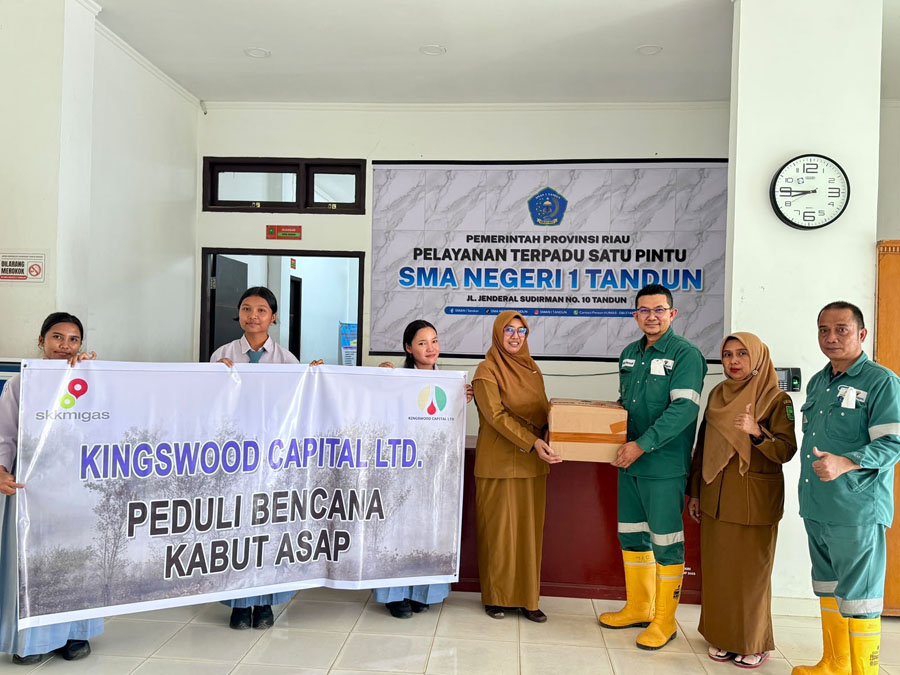 Rafiq Adriansyah selaku Head of Field Support dan Supriadi selaku Public & Government Relation Kingswood Capital Ltd. Menyerahkan masker kepada Nur Hayati selaku Kepala Sekolah SMAN 1 Tandun