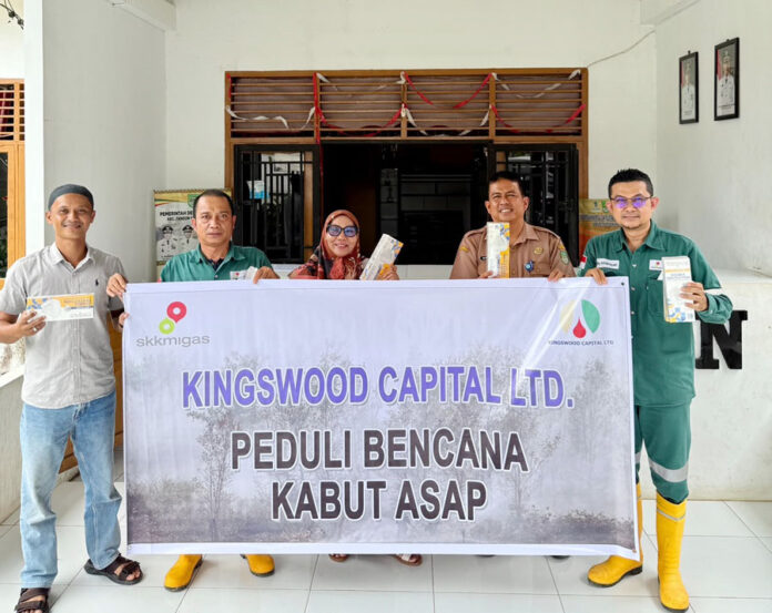 Rafiq Adriansyah selaku Head of Field Support dan Supriadi selaku Public & Government Relation Kingswood Capital Ltd. Menyerahkan masker kepada Ali Yusuf selaku Kepala Desa Koto Tandun
